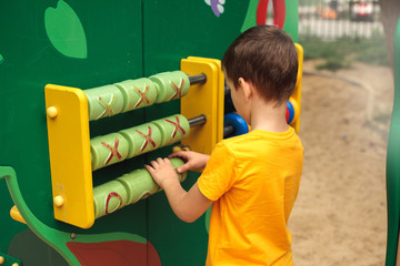 A boy at the playground plays a game, rear view. Children's sports, leisure, hobbies.