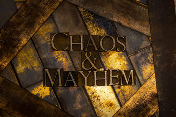 Photo of real authentic typeset letters forming Chaos and Mayhem text on vintage textured grunge...