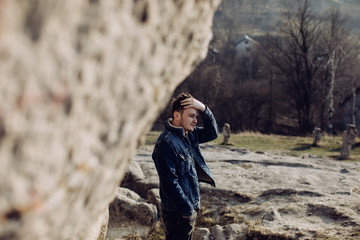 Fototapeta premium Portrait of a young man in the mountains alone