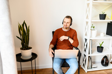 Guy uses headsets and laptops to work at home