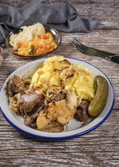 Fried liver with onion and apple, served with boiled potatoes and pickled cucumber.