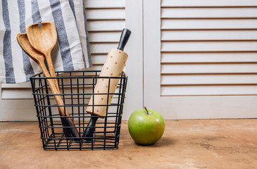 Kitchen utensils in a black basket. Home kitchen decor background with space for a text. Zero waste concept