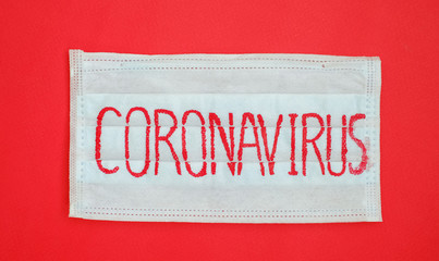 Medical mask with the inscription Coronavirus on a red background