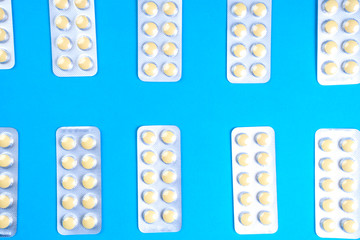 Tablet pills in blister packs pattern on blue background