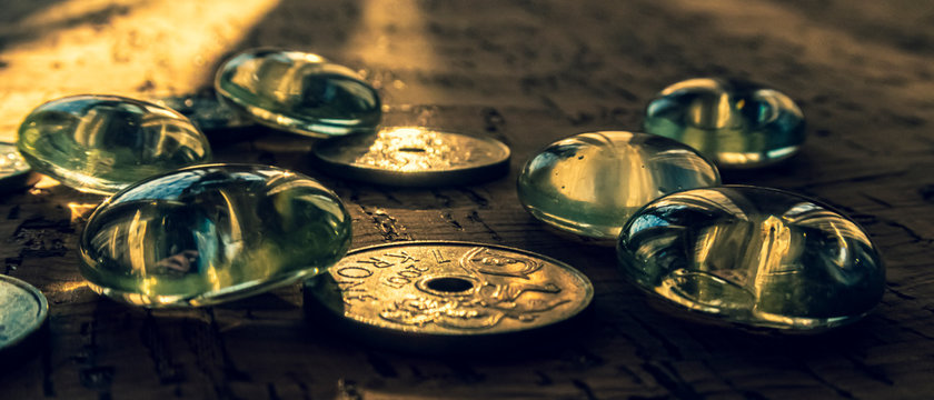 Closeup of a pile of Norwegian money on a cork background, illuminated by a beam of sunlight.