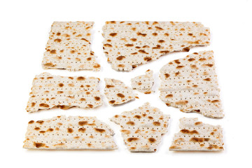 Matzo. Traditional jewish easter bread. Passover holiday symbol. Broken matzo, lies in a heap. Isolated on white. With some free space for your text or sign. Close-up.