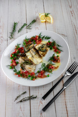 Fillet of zander, rosemary, thyme, lemon and vegetables on a plate in a restaurant