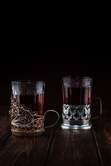 two glasses of tea in cup holders on a wooden table, concept of restaurant menu with copy space