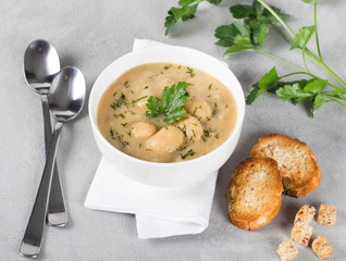 Bean cream soup with meatballs, parsley and croutons in a bowl on a light background