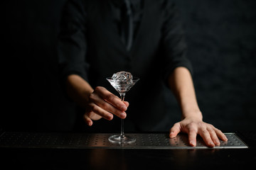 close-up of martini glass with piece of ice on bar counter