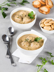 Bean soup-puree with meatballs and croutons in a bowl on a light background