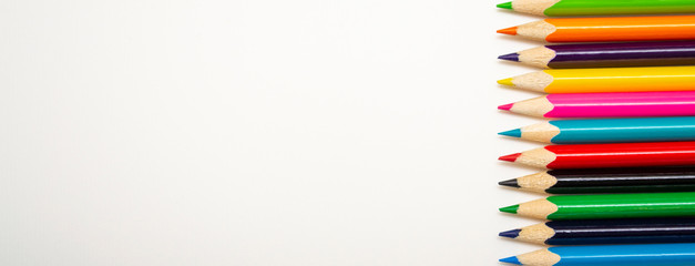 Multi-colored pencils on a white background with copy space.