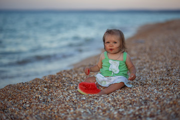 little girl child sitting on the beach and eating watermelon, summer, beach