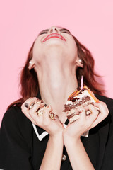 Beautiful woman holding a cake in the hands of the charm and delight of sweets