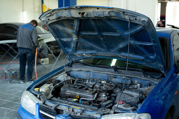 A car with an open hood in service