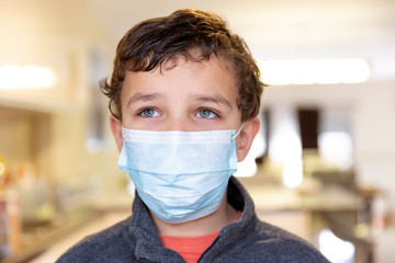 Portrait of handsome boy  wearing surgical mask for coronavirus protection.