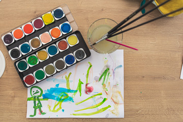 Child painting with water colors on a table