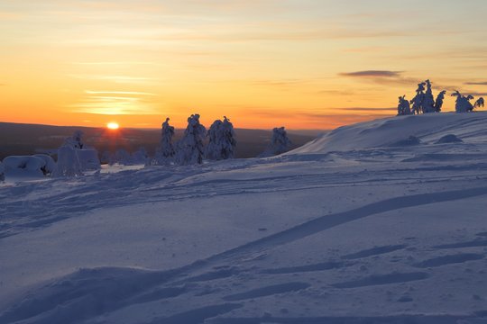 Wintry countryside with sun on horizon in Yll&auml;s in Finnish Lapland