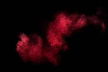 Red and pink powder explosion on black background. Colored powder cloud. Colorful dust explode. Paint Holi.