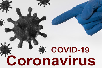 A blue-gloved hand gesture pointing at the coronavirus particles with its index finger. Inscription covid-19 coronavirus