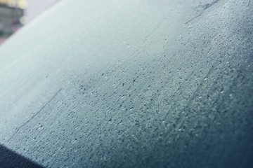 Raindrops on the hood of the car. Close-up.