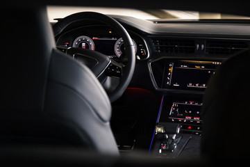 Interior of an ultra modern new luxury car. Leather chairs and wood trim, touch panels with vibration feedback and climate control. Multifunction, automatic transmission