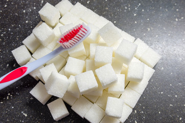 toothbrush on the background of the sugar cubes of refined sugar, preventing tooth decay, caring...