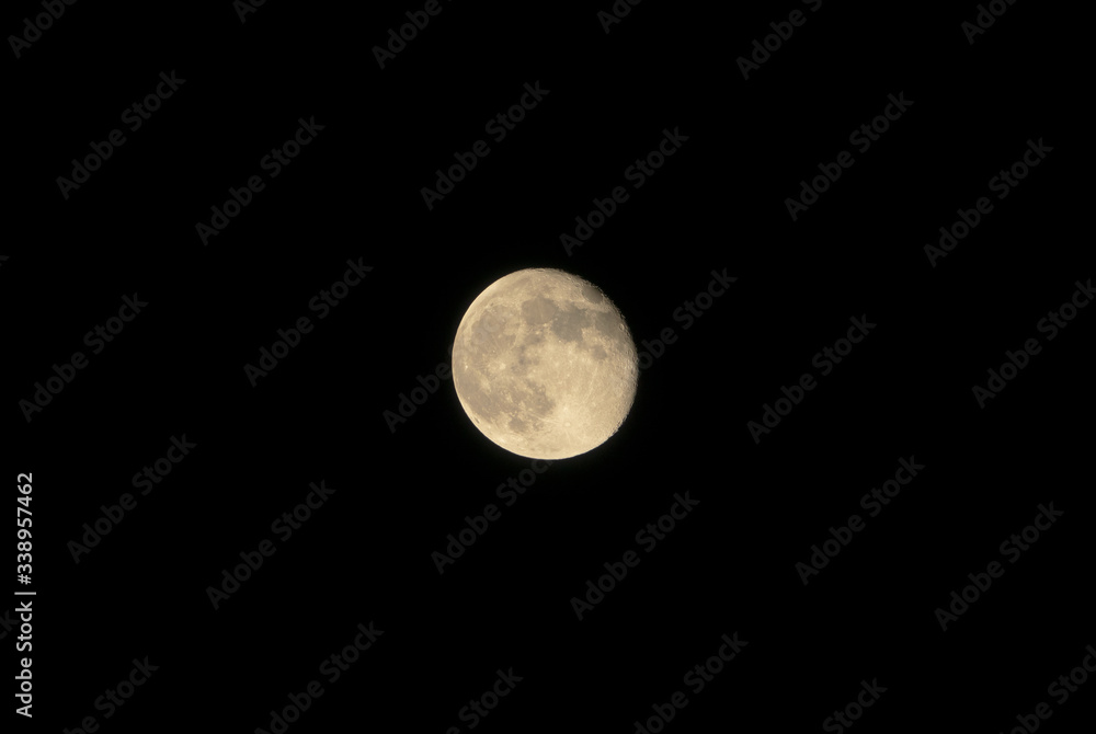 Wall mural full moon glowing on black background.