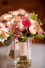 Red and white rose wedding bouqet in a vase with water