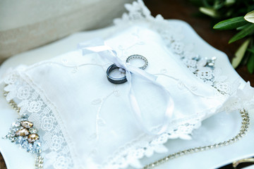 two gold wedding rings on a pillow