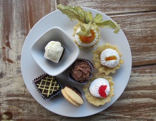 Plato con postres de un bufete sobre una mesa de madera