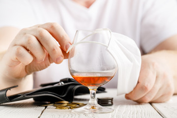 A man wearing medicing mask posing with a glass of alcohol, indoor portrait