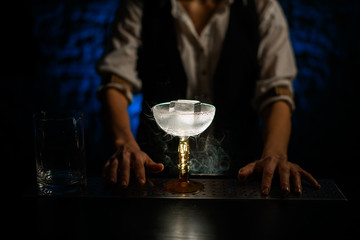 close-up of transparent glass with large piece of ice standing on bar counter