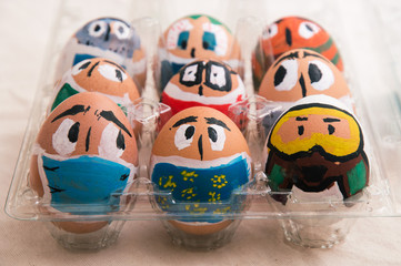Close up. Easter eggs painted as faces with medical masks.