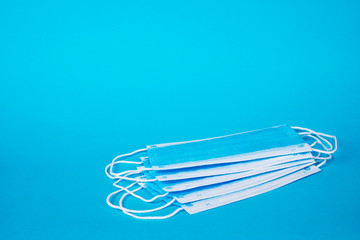 Protective Surgical Ear-Loop Masks on Blue Background.