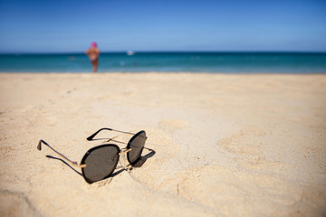 sunglasses with on the sand on a Sunny summer beach.