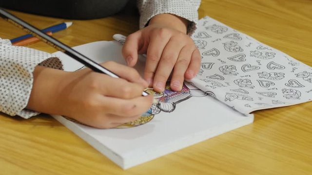Hands of children of close up. Children drawing coloring picture.