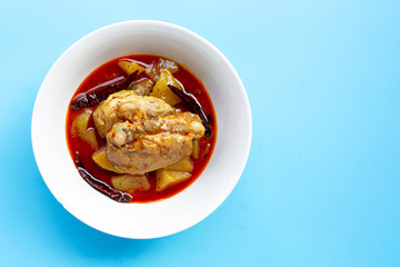 Mussaman curry with chicken and potato on blue background.