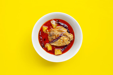 Mussaman curry with chicken and potato on yellow background.