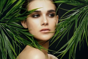 Naklejka premium Beautiful woman green leaves exotic beach tropics at luxury
