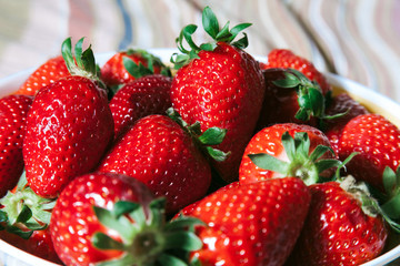 Isolated heap of juicy red strawberries with selective focus.