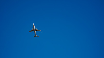 Fototapeta premium Airplane Across Ocean Blue Sky