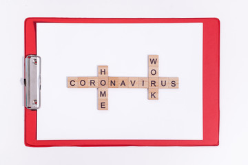 Text from wooden letters coronavirus work from home. Office red tablet on the desktop. Flatley layout isolated on a white background. Minimalistic office concept. Working during a virus pandemic.