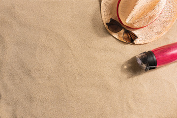 Fototapeta na wymiar Summer vacation composition. Water bottle, straw hat and sunglasses on sand