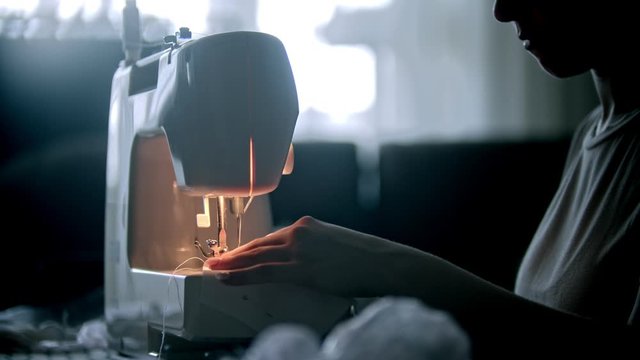 Young woman seamstress sewing a reusable mask