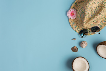Obraz premium Summer composition. Sunglasses, hat, coconut on blue background. Summer concept. Flat lay, top view, copy space