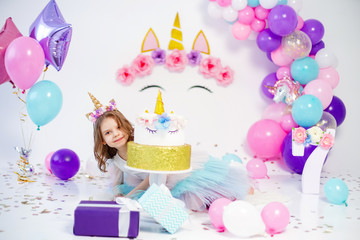 Unicorn Girl posing near happy birthday cake. Idea for decorating unicorn style birthday party....