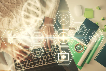 Double exposure of woman hands working on computer and DNA hologram drawing. Top View. Medical education concept.