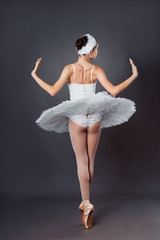 Portrait from back. Ballerina dancing in white dress. Graceful ballet dancer or classic ballerina...