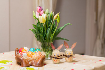 Easter holiday with colored eggs and flowers. colorful tulips near the painted Easter eggs of...